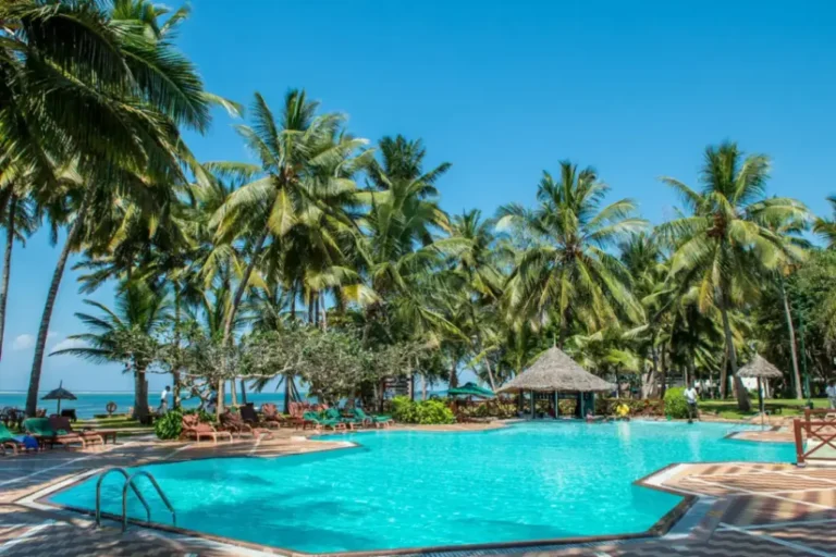 Poolside at Serena Beach Resort & Spa in Mombasa, featuring palm-lined gardens, turquoise swimming pool, and coastal Swahili architecture.