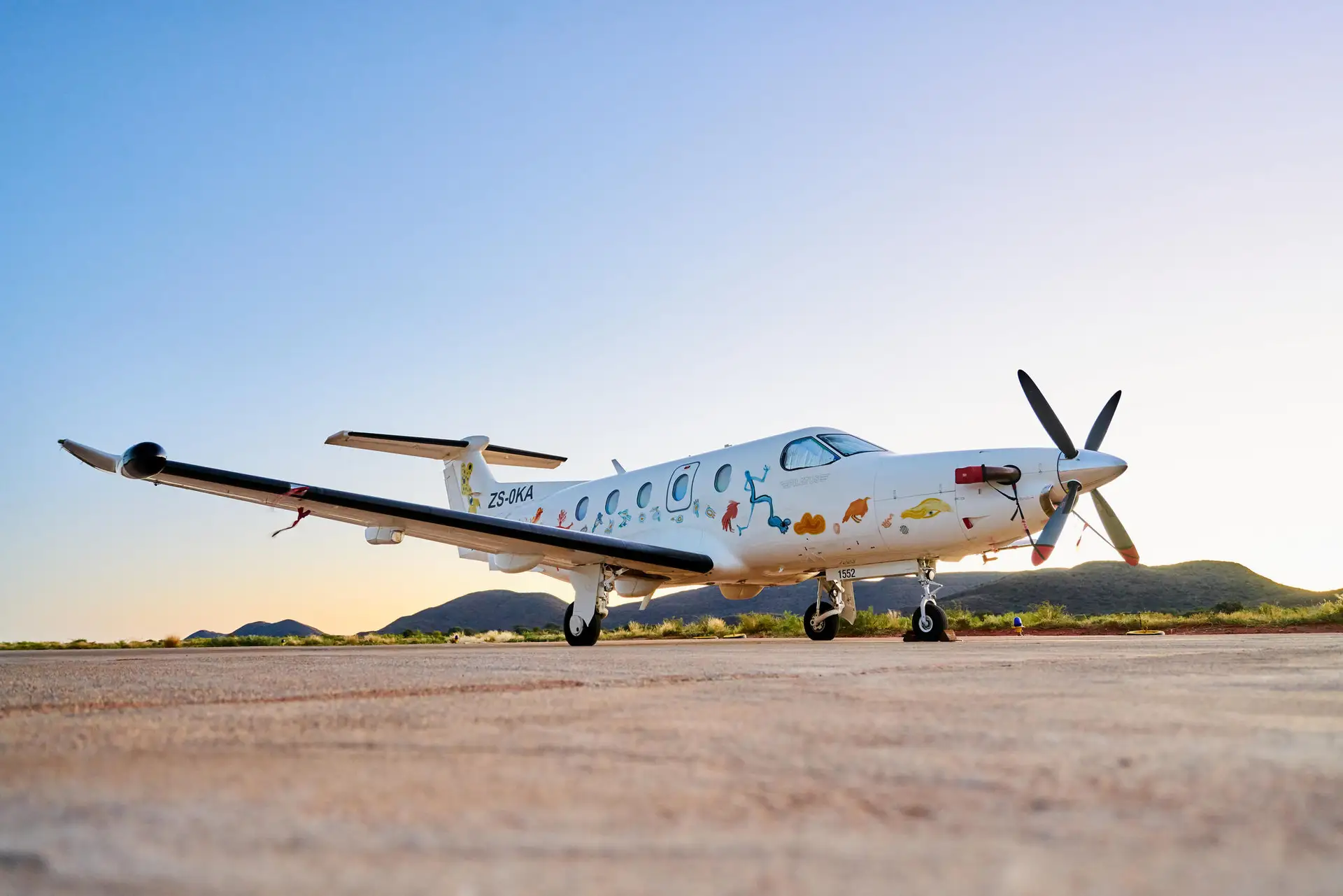 A private charter plane landing on a remote airstrip with sweeping views of the Kalahari Desert.