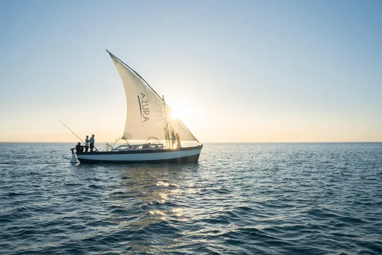Traditional wooden dhow sailing along the turquoise waters of Benguerra Island at Azura Benguerra Resort, Mozambique.