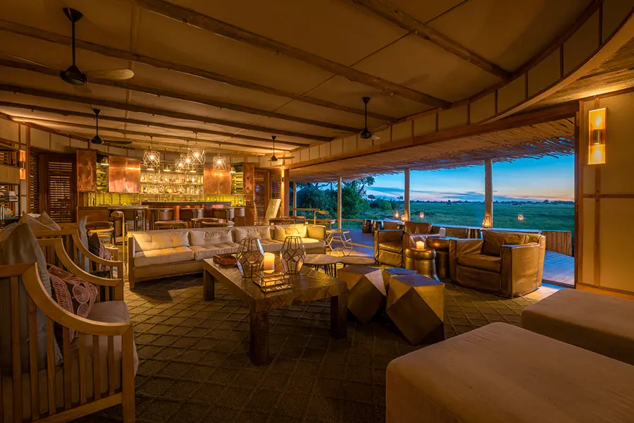 Interior communal lounge area at Wilderness Mombo Camp overlooking the Okavango Delta floodplains