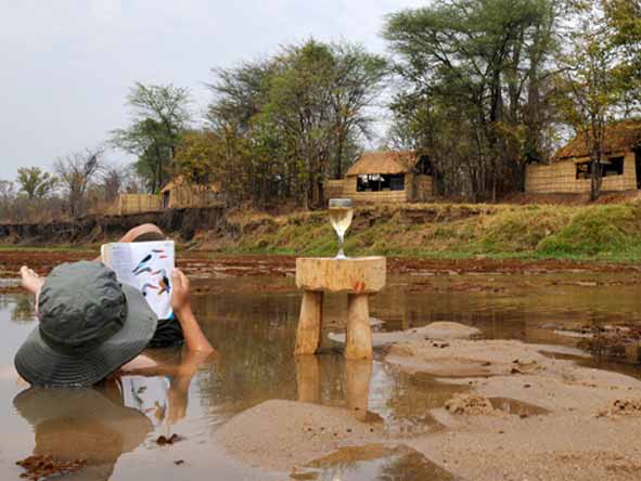 Guests cooling off in the shallow waters of the Mwaleshi River near Mwaleshi Camp in Zambia