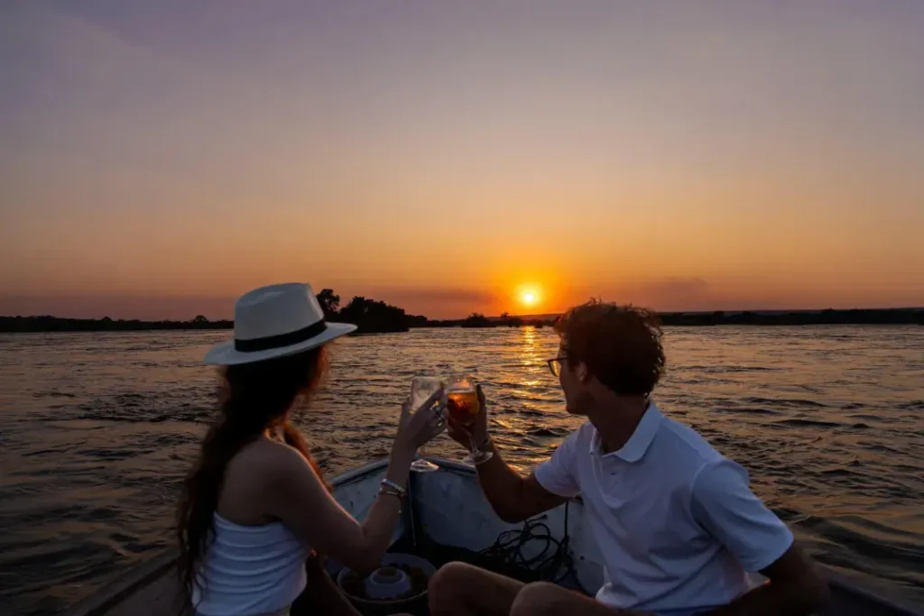 Romantic honeymoon couple enjoying champagne on a sunset safari in Africa