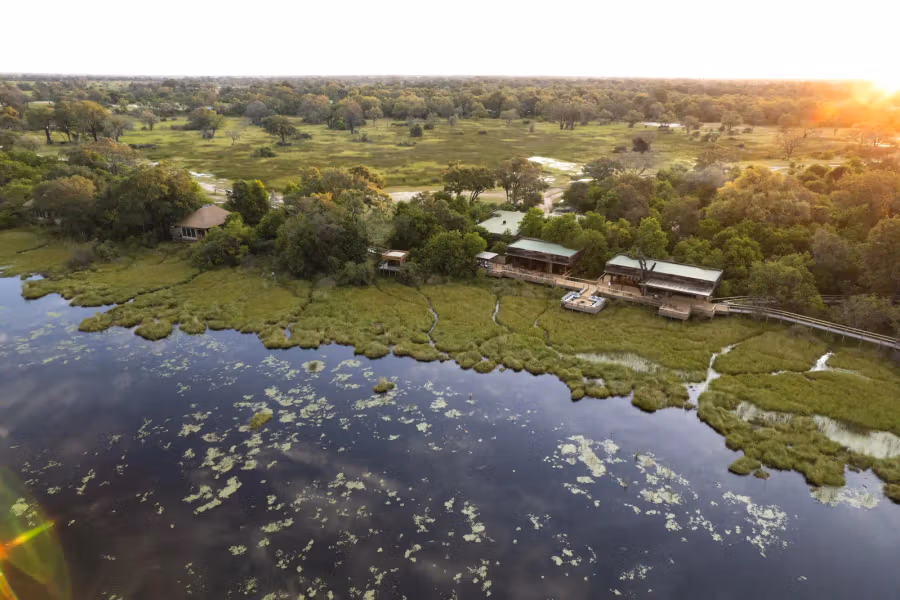 Aerial view of Vumbura Plains luxury safari camp surrounded by Okavango Delta waterways and floodplains in Botswana